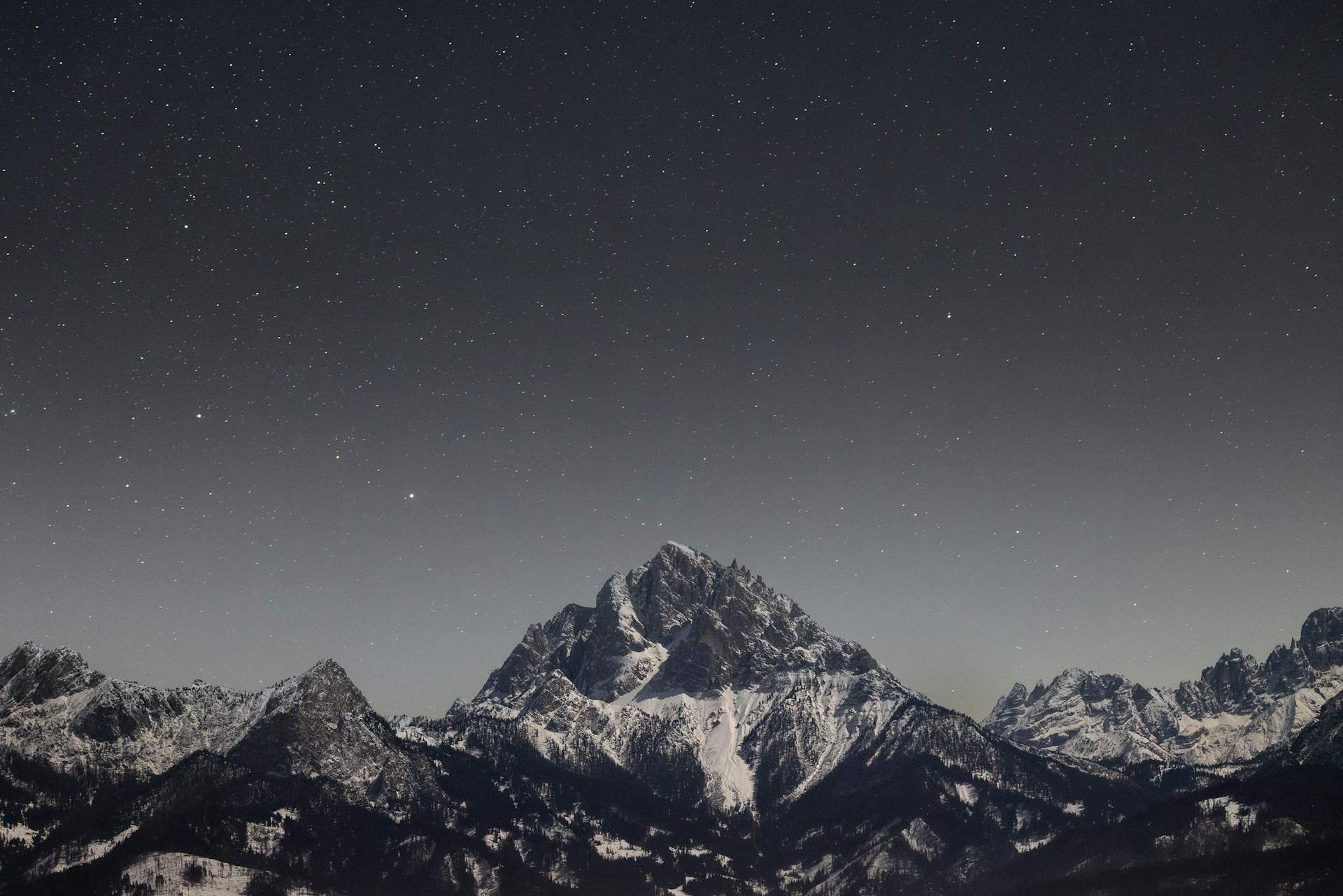 星空下的雪山群峰，山脊线横展于夜色